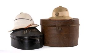 MILITARY CLUB HOUSE: PITH HELMETS IN ORIGINAL METAL HAT BOXES, to include a pre-war British Royal