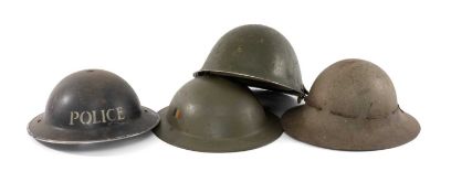 MILITARY CLUB HOUSE: FOUR TOMMY STYLE STEEL HELMETS, to include a circa 1940s WWII dark blue/black