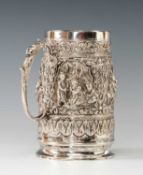 GOOD BURMESE SILVER TANKARD, tapering cylindrical form, decorated in high relief with arched