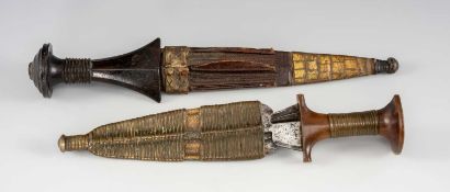 TWO AFRICAN DAGGERS, comprising a Sudanese dagger with ring-carved hilt, plain blade, in leather and
