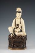 CHINESE CIZHOU STYLE FIGURE OF GUANYIN, seated on dais holding a child, 29.7cms (h) Provenance: