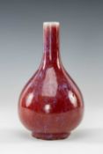 CHINESE SANG-DE-BOEUF PORCELAIN BOTTLE VASE, of onion form with tall narrow neck on short foot, 20.