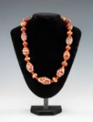TIBETAN DZI BEAD NECKLACE, composed of 23 large and small carnelian or red agate beads, and small