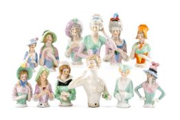 ASSORTED GERMAN PORCELAIN PIN CUSHION DOLLS TORSOS, of various forms, some holding flowers, most