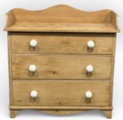 19TH CENTURY PINE CHEST with raised back and sides, three drawers with white ceramic knob handles,