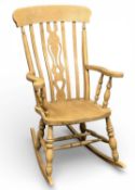 MODERN BEECH FARMHOUSE ROCKING CHAIR with pierced splat and shaped rail back, outswept open arms,