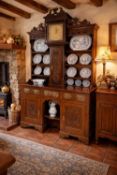 UNUSUAL CARVED OAK HOUSEKEEPER'S WELSH CLOCK DRESSER, 19th century and earlier, centred with a