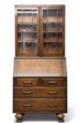 EDWARDIAN OAK BUREAU BOOKCASE, topped with glazed doors and multiple adjustable shelves, and a