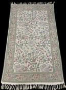 CREWEL WORK RUG in cream ground, with purple, blue and green foliate decoration, 150 x 90cms
