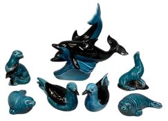 POOLE POTTERY, seven black and teal blue glazed animal figures, the largest, two dolphins 25cms (
