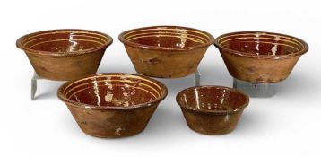FIVE 19TH CENTURY BUCKLEY WARE DAIRY BOWLS, 34cms (diam.) the larger Provenance: private