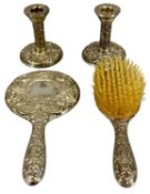 PAIR OF CIRCULAR SILVER CANDLESTICKS, repoussé decoration, loaded bases, 10cms (h); with a silver-