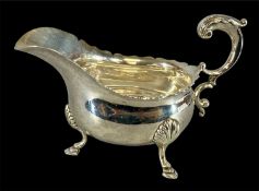 LARGE GEORGE V SILVER SAUCEBOAT with acanthus capped scroll handle, on three hoof feet, Haseler