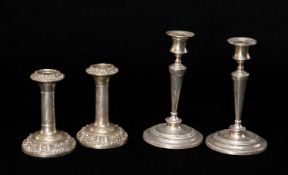 TWO PAIRS OF SILVER CANDLESTICKS both with loaded bases, one plainn tapering form, 20cms h, the