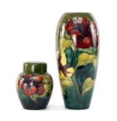 TWO MOORCROFT POTTERY VASES, 'Hibiscus' pattern, comprising slender oviform vase 31.5cms (h), and