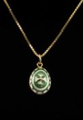 ENAMELLED GOLD EGG-FORM PENDANT in the Russian style, finished in green and white enamel, marked '