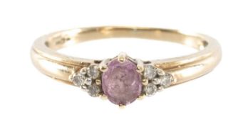 PINK SAPPHIRE & DIAMOND RING in 9ct gold, the small oval-cut sapphire flanked by tiny brilliants,