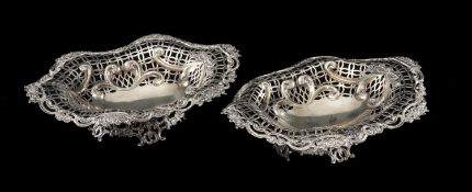 PAIR OF VICTORIAN OVAL SILVER FOOTED BASKETS, embossed and pierced with foliate borders,