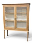 PINE GLAZED TWO-DOOR BOOKCASE, with shelved interior, on open stand, 186 (h) x 140 (w) x 47cms (d)