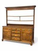 GEORGE III OAK WELSH DRESSER, open plate rack back with three shelves, mahogany cross banded base