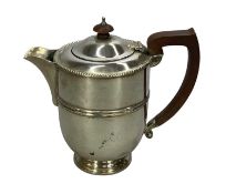 GEORGE V SILVER HOT WATER JUG, of circular form, with gadrooned rim, wooden handle and finial,