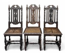 VICTORIAN OAK HALL TYPE CHAIRS, three similar, one with a caned seat, all with carved backs (3)