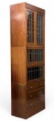 20TH CENTURY OAK LIBRARY BOOKCASE, with up and slide-under type leaded glazed doors and three