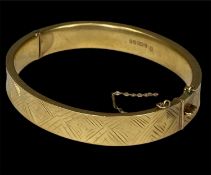 9CT GOLD HINGED BANGLE, with safety chain, 65 x 60mms, 15.5g Provenance: deceased estate Ynys Môn