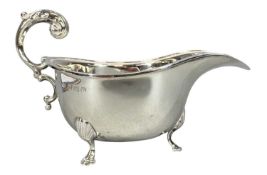 GEORGE V SILVER SAUCEBOAT with acanthus-capped scroll handle, on three hoof feet, Birmingham 1940,