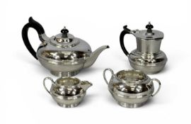 GEORGE V SILVER FOUR-PIECE TEA SERVICE, of circular waisted form, ebonised handles and finials to