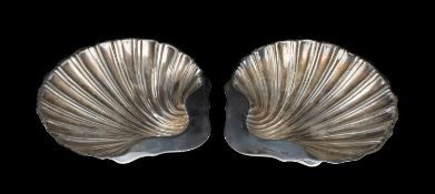 PAIR OF SILVER SHELL-FORM DISHES each raised on three ball feet, Goldsmiths & Silversmiths Co., date