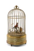 SINGING BIRD AUTOMATON in gilt metal cage, the red and yellow birds amid leafy vine, 20th Century,