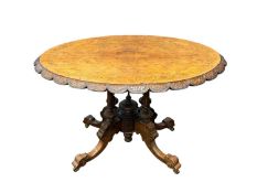 VICTORIAN INLAID WALNUT LOO TABLE having an oval tilt top with carved shaped apron, four turned