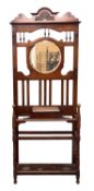 EDWARDIAN MAHOGANY HALL STAND incorporating a circular bevelled glass mirror, metal hangers, drip
