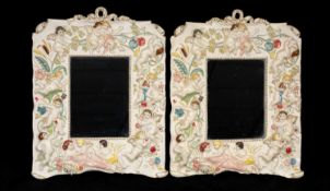 PAIR OF SPELTER FRAMED WALL MIRRORS, colourful painted repoussé decoration of cherubs, 29.5 x