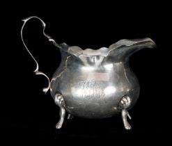 EDWARD VII SILVER CREAM JUG with shaped rim, loop handle, on four paw feet, George Nathan & Ridley