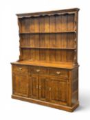 SOLID OAK WELSH DRESSER, in the 18th century style, with boarded plate rack, enclosed base with