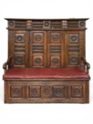 19TH CENTURY FRENCH BRETON FARMHOUSE DARKENED OAK BOX SEAT SETTLE, heavily carved in the regional