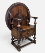 JACOBEAN STYLE CARVED OAK 'TABLE-CHAIR', circular slide & tilt table-top with carved decoration,