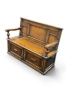 HONEYED OAK BOX SETTLE in the Revivalist style, circa 1910, with panelled back, box base with lift-