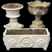 TWO COMPOSITE STONE GARDEN URNS, largest 60cms (h); white-painted composite plant trough, 30 (h) x