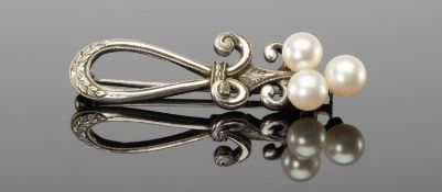 MIKIMOTO PEARL & SILVER BROOCH, mounted with three small pearls to a laurel engraved double scrolled