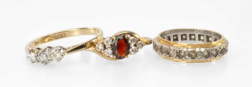 THREE GOLD RINGS comprising 9ct gold diamond three-stone ring, 1.7g; 9ct garnet and white gem