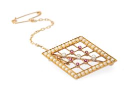 ATTRACTIVE EDWARDIAN DIAMOND, RUBY & PEARL TRELLIS BROOCH set in unmarked yellow gold, centred