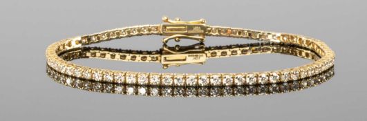 10CT GOLD DIAMOND TENNIS BRACELET, set in yellow gold with 69 small round brilliant-cut diamonds,