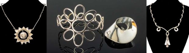 FOUR ITEMS OF CONTEMPORARY SILVER JEWELLERY, comprising an oval polished brooch, sun pendant