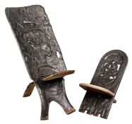 TWO AFRICAN TWO-PIECE CHAIRS, the larger heavily carved to the back with figures, 95cms (h), the