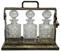 EPNS TANTALUS containing three square cut glass decanters and stoppers, 30 (h) x 34.5 (w) x 13.