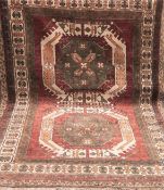 Teppich, auf rostbraunem Grund grünlich ornamental gemustert, Rand mit Riß und Loch, Fransen unters
