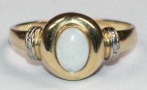 Opal-Ring, 585er GG, ovaler Opal-Cabochon, Ringschultern mit Rillenrelief besetzt je mit 1 kl. Bril